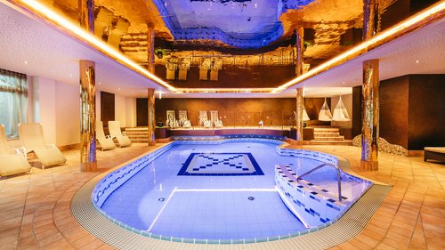 Willkommen im Hotel in Neustift im Stubaital! Moderner Innenpool mit blauen Fliesen und goldener Deckenreflexion